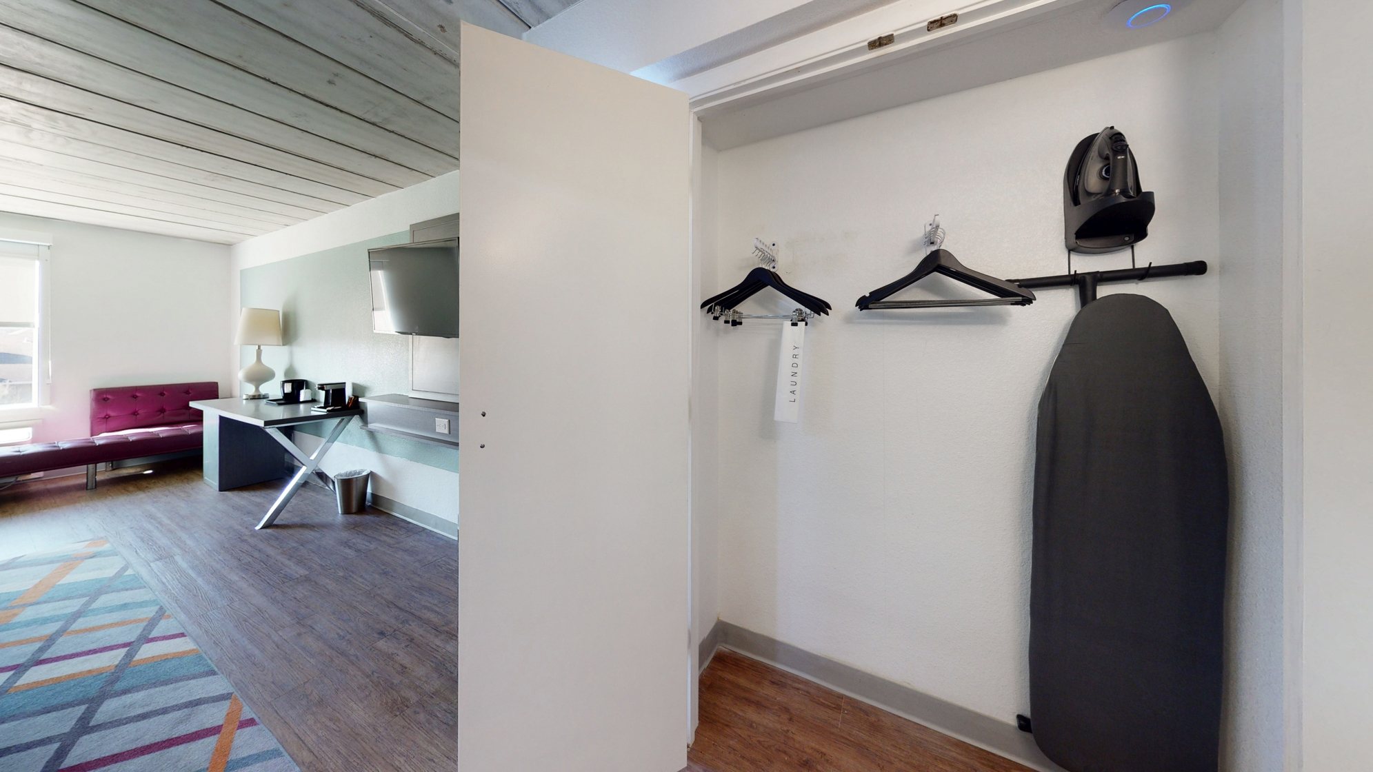 Open closet with Iron and Board along with hangers